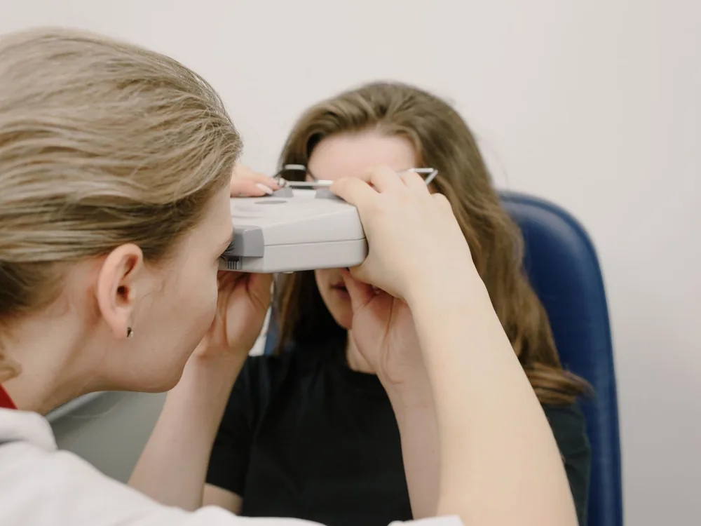 Orthoptist assessing a patient’s binocular vision with a testing instrument in Medellín