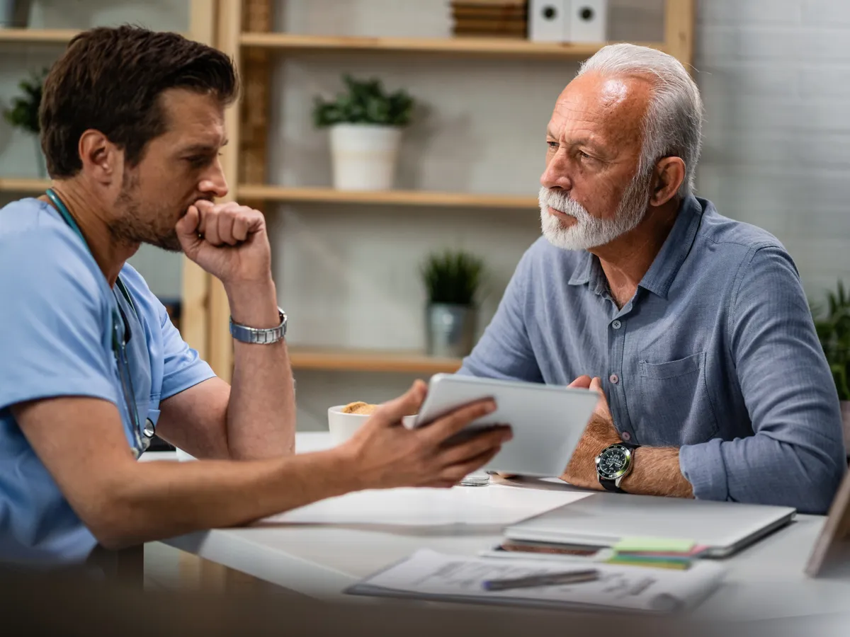 Older man reviewing his incontinence test results with the urologist after a prostatectomy