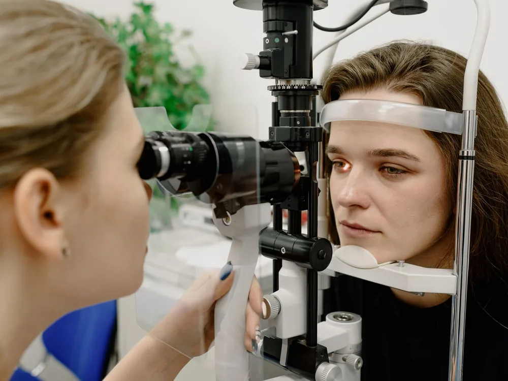 Oftalmóloga examina los ojos de una paciente con lámpara de hendidura en una consulta de oculoplastia en Medellín
